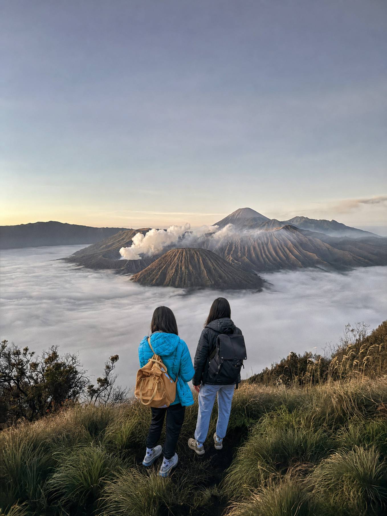 Two travelers overlooking Mount Bromo at sunrise