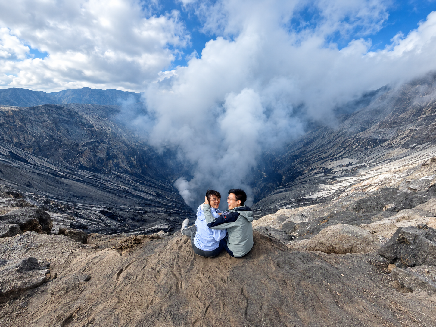 Two travellers together at the active Mount Bromo crater rim