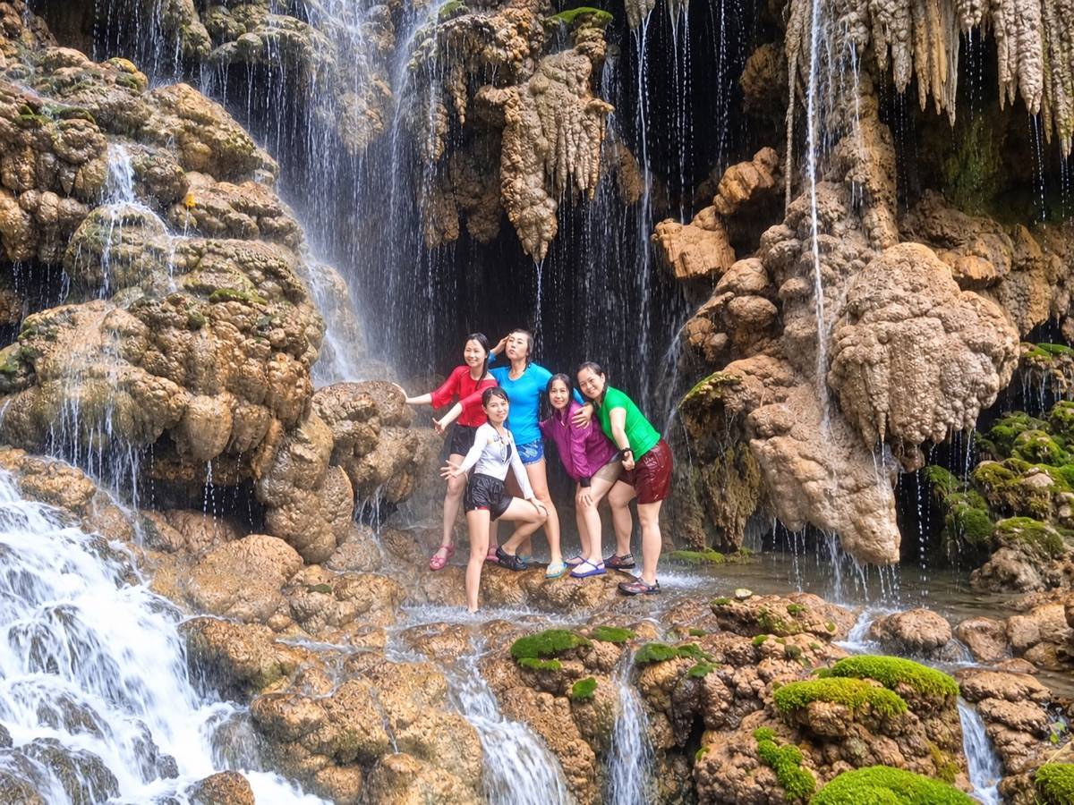 Travellers at Goa Tetes waterfalls and cave formations